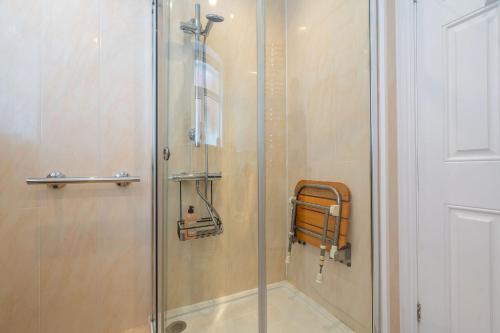 a shower with a glass door in a bathroom at Nature Inspired Bungalow with 3 rooms - 10 mins from Manchester Airport in Timperley