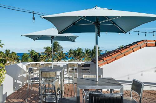 a patio with tables and chairs and an umbrella at Marriott Vacation Club, South Beach in Miami Beach