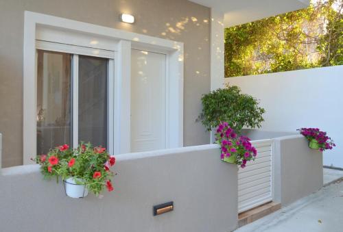 a house with two potted flowers on a balcony at Tile Apartments #2 in Agia Marina Nea Kydonias