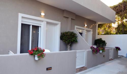 a white fence with flower pots on the side of a house at Tile Apartments #2 in Agia Marina Nea Kydonias