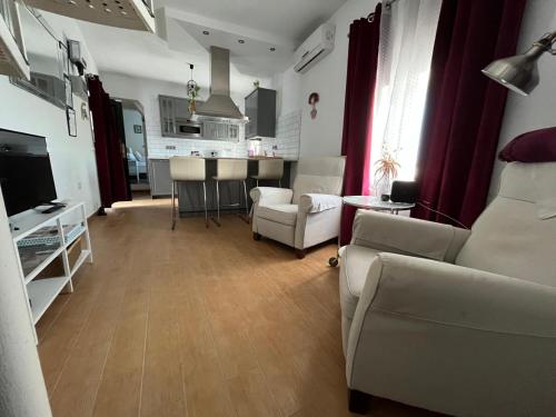 a living room with a couch and chairs and a kitchen at Casa Patricia I in Arcos de la Frontera