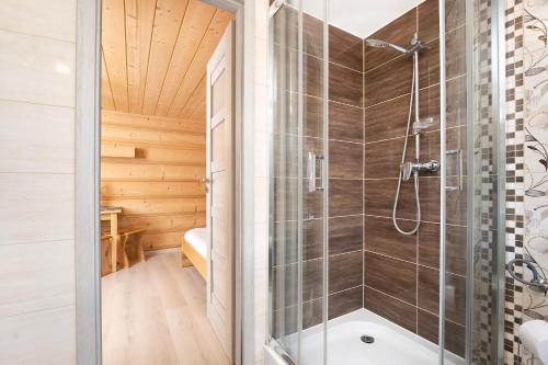 a bathroom with a shower in a log cabin at Willa Emilia in Zakopane