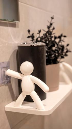 a white toy figure sitting on a shelf next to a vase at Villa Melissa in Portianón