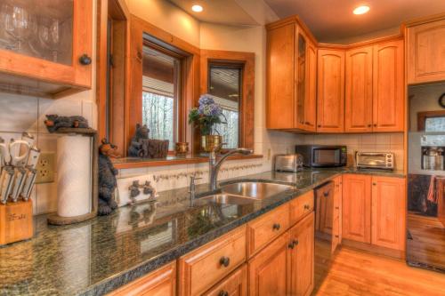 a kitchen with wooden cabinets and a sink at Most Luxury 7000 Sq ft Log Estate with Pool Hot Tub Sauna in Wilmington