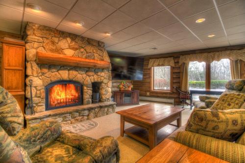 a living room with a large stone fireplace at Most Luxury 7000 Sq ft Log Estate with Pool Hot Tub Sauna in Wilmington