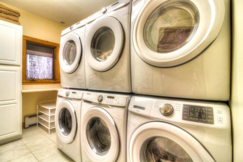 three washing machines stacked on top of each other in a laundry room at Most Luxury 7000 Sq ft Log Estate with Pool Hot Tub Sauna in Wilmington