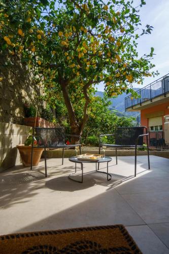 a table and two benches under an orange tree at The Upper House in Riomaggiore
