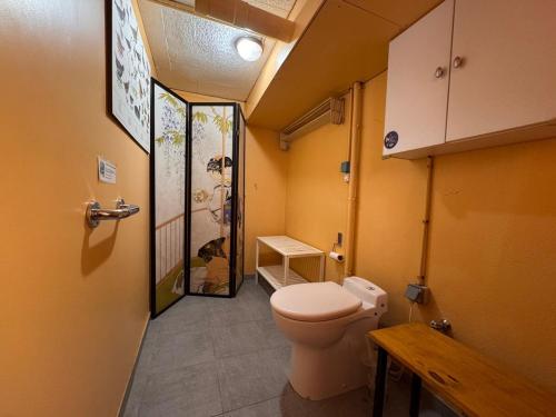 - une petite salle de bains avec des toilettes et une porte dans l'établissement Les Iris, appartement modeste en sous-sol, à Saint-Valery-sur-Somme