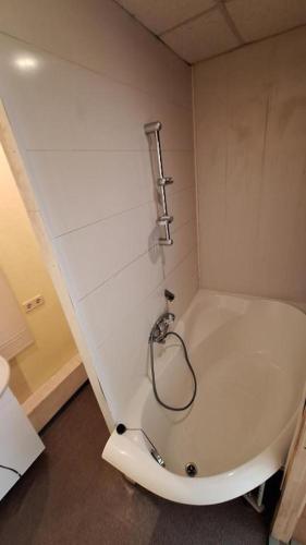 a bathroom with a bathtub with a hose on the wall at Jurmala Beach in Jūrmala