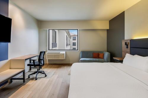 a hotel room with a bed and a desk and chair at Fiesta Inn Monterrey la Fe in Monterrey