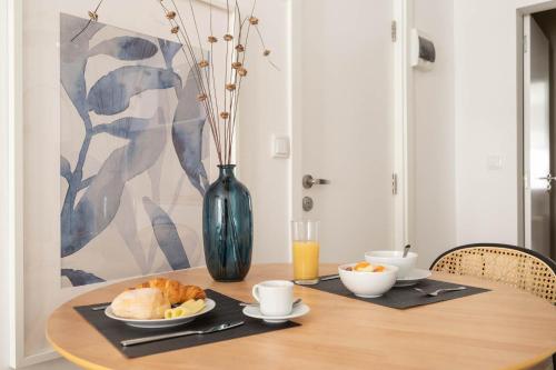 a table with a plate of bread and a vase at Lapa Diplomatic Suites & Flats by Feel Lisboa in Lisbon