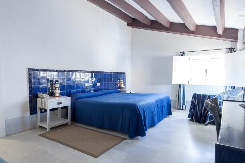 a bedroom with a blue bed and a table at Doña Pakyta in San José