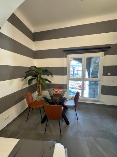 a dining room with striped walls and a table and chairs at Suite degli Archi - Genova Fronte Acquario in Genova
