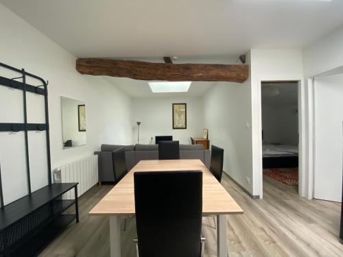 une salle à manger avec une table et un canapé dans l'établissement Appartement 4 personnes, à Parthenay