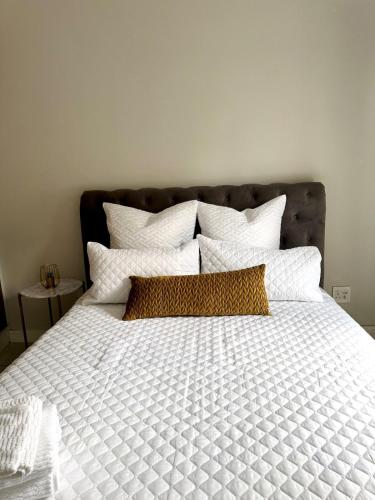 a large bed with white sheets and pillows at 126Theblyde in Pretoria