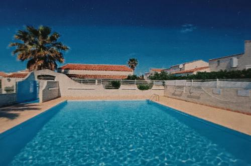 une grande piscine bleue devant une maison dans l'établissement Casa sand, au Cap d'Agde