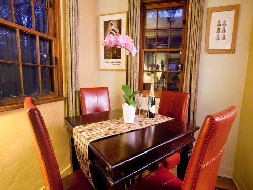 a dining room with a table with red chairs at Casa de Tres Lunas/House of Three Moons in Santa Fe
