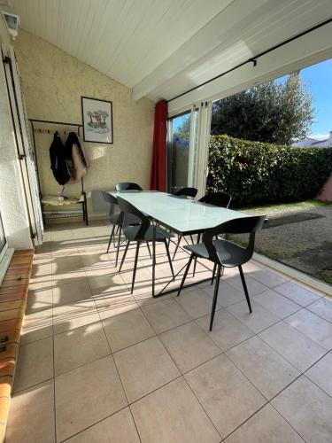 une table et des chaises en verre sur la terrasse dans l'établissement Casa sand, au Cap d'Agde