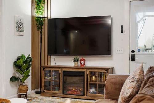 a living room with a flat screen tv above a fireplace at Beach Block 2-Bed with Coastal Palm Trees and Yard in Pacifica