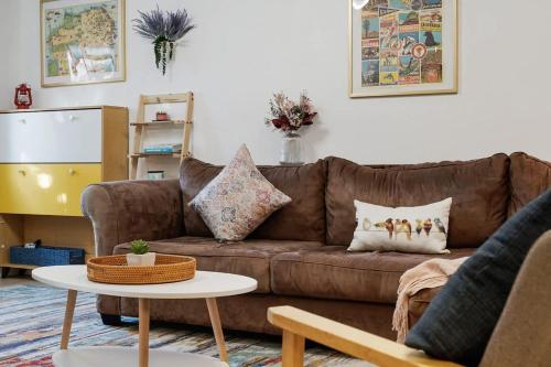 a living room with a brown couch and a table at Beach Block 2-Bed with Coastal Palm Trees and Yard in Pacifica