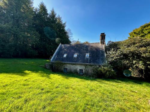 an old stone house in a field with grass at Gîtes du Gohic - Le Cidre in Quistinic