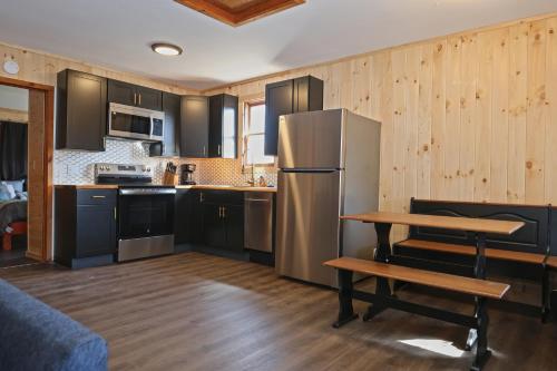 a kitchen with black cabinets and a stainless steel refrigerator at Private Hot tub new 2 Bedroom Home in Catskills in Elka Park
