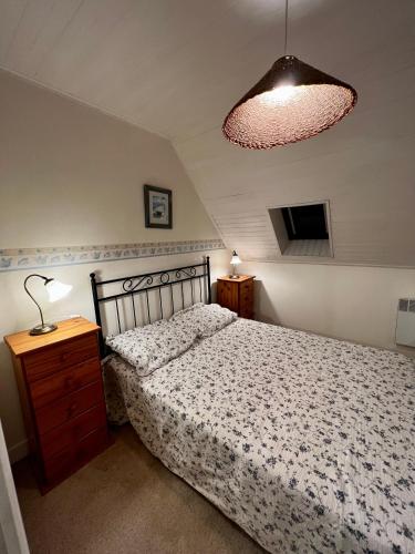 a bedroom with a bed and a lamp and a light at Gîtes du Gohic - Le Cidre in Quistinic