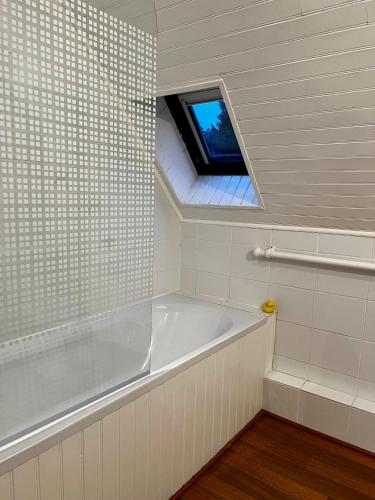 a bathroom with a bath tub and a window at Gîtes du Gohic - Le Cidre in Quistinic
