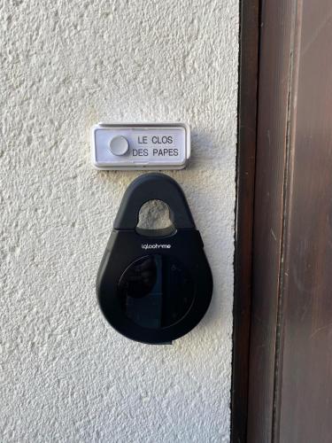 une poignée de porte noire et un panneau de passage pour chien sur un mur dans l'établissement Le Clos des Papes, à Avignon