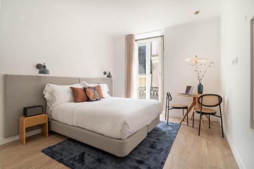 a bedroom with a bed and a table with chairs at Lapa Diplomatic Suites & Flats by Feel Lisboa in Lisbon