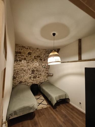 - une chambre avec 2 lits dans une chambre dotée d'un mur en briques dans l'établissement Grange rénovée dans cour privée avec jardin sur les remparts, à Bergheim