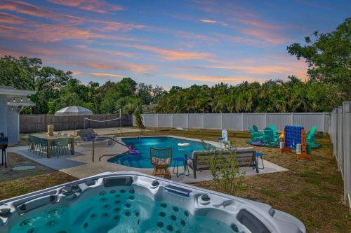 a backyard with a pool with a table and chairs at Backyard Oasis w Sand Volleyball Mins to Beach in Seminole