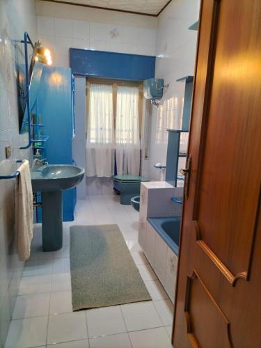 a blue bathroom with a sink and a toilet at Nonno Nanni casa vacanze in Portocannone
