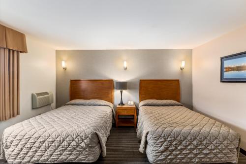 a hotel room with two beds and a table at Breeze Inn Hotel in Seward