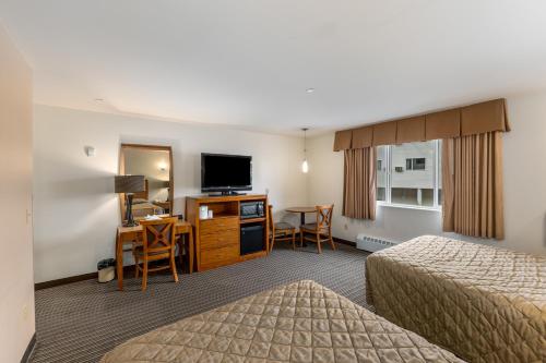 a hotel room with two beds and a flat screen tv at Breeze Inn Hotel in Seward