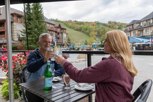 a man and woman sitting at a table drinking wine at The Westin Trillium House, Blue Mountain in Blue Mountains