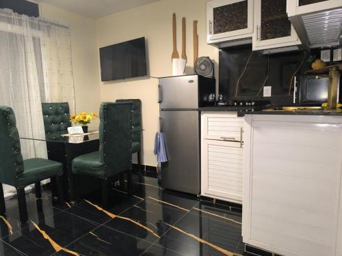a kitchen with a refrigerator and a table with chairs at Escape en terrazas del caribe con psicina y playa in Boca Chica