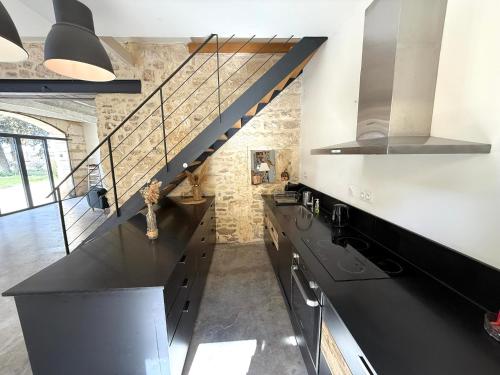 a kitchen with a black counter top and a staircase at Domaine la Clausade in Mauguio
