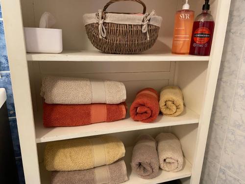 a towel shelf with towels and a basket on it at La Maison Rouge in Chinon