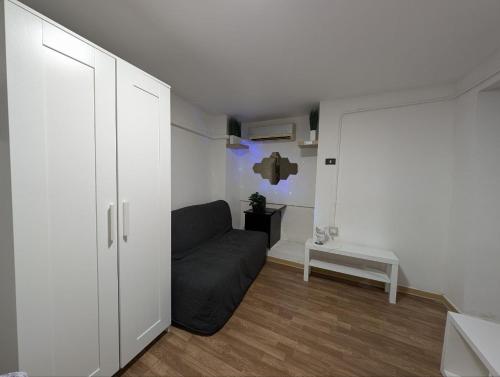 Cozy Loft in Historical Center في جينوا: غرفة معيشة مع أريكة سوداء في غرفة