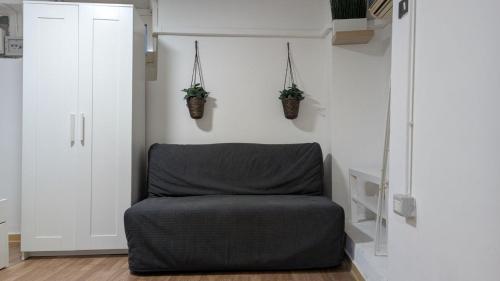 Cozy Loft in Historical Center في جينوا: غرفة بها سرير ونباتات مزروعة في أصيص على الحائط