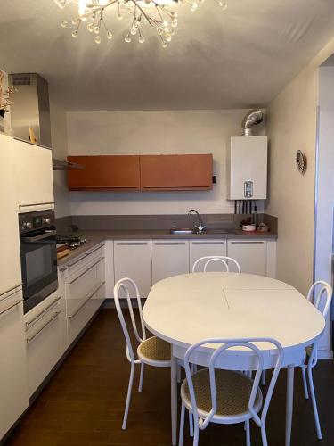 une cuisine avec une table blanche et des chaises dans l'établissement T2 Spacieux à Carnon, à Mauguio
