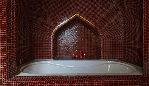 a bath tub in a red tiled bathroom with a window at Der Zauberlehrling in Stuttgart