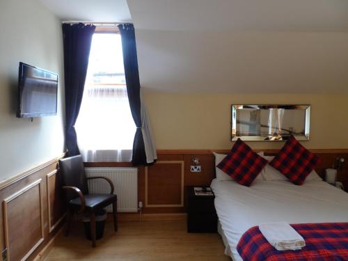 1 dormitorio con 1 cama, 1 silla y 1 ventana en Bala House, en Edimburgo