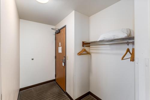 a room with a closet with a door and a shelf at Breeze Inn Hotel in Seward