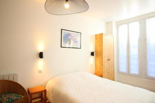 une chambre avec un lit et une grande fenêtre dans l'établissement Appartement T2 - RDC à 300M des thermes - La villa blanche, à Le Mont-Dore