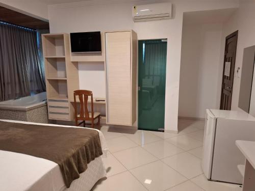 a hotel room with a bed and a bathroom at Brisas do Mar HOTEL & APART in Valença