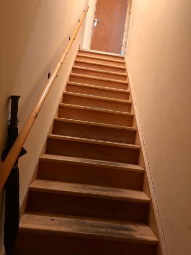 a stairway with wooden stairs in a building at Cozy flat in High Wycombe