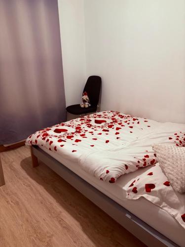 a bed with red roses on it in a room at Cozy flat in High Wycombe