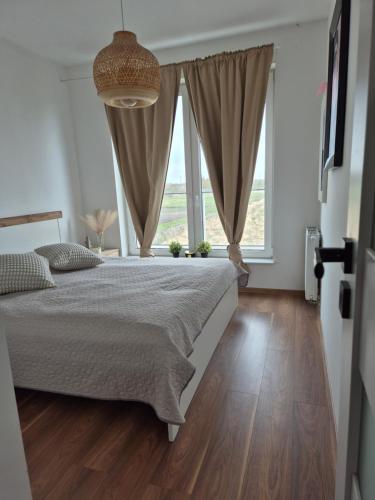una camera da letto con un letto grande e una grande finestra di Apartament Słoneczny Taras przy Aquapark Reda a Rumia